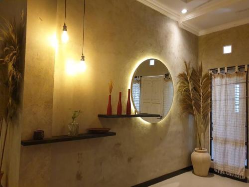 W pokoju znajduje się łazienka z lustrem i umywalką. w obiekcie Nebara Casa w mieście Yogyakarta