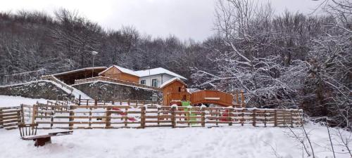een huis met een houten hek in de sneeuw bij Bonsovi Poliani Hut (хижа Бонсови поляни) in Vladaya
