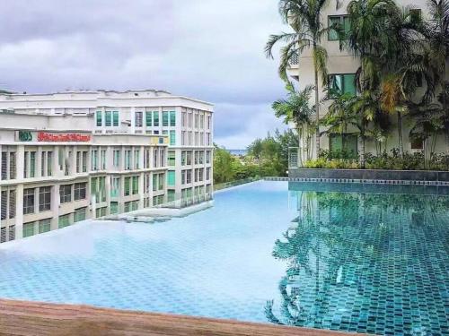a large swimming pool in front of two buildings at Deluxe Sunrise Suite 3 bedroom 2000sqft Condo Loft B side seaview above Imago Shopping Mall in Kota Kinabalu