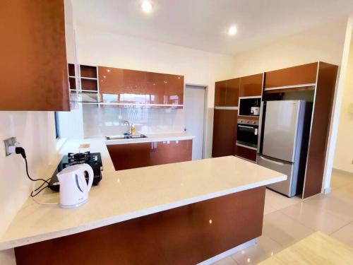 a kitchen with a counter top and a refrigerator at Deluxe Sunrise Suite 3 bedroom 2000sqft Condo Loft B side seaview above Imago Shopping Mall in Kota Kinabalu