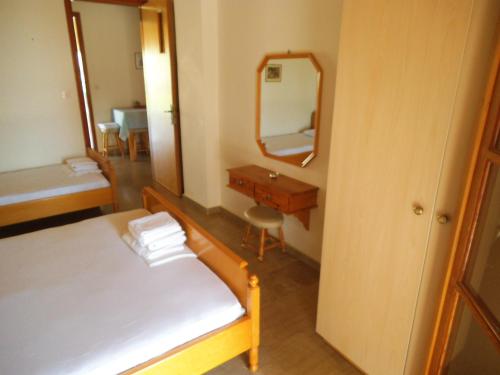 a bedroom with a bed and a desk and a mirror at Villa Xenos in Kalamaki