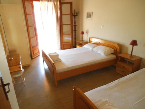 a bedroom with two beds and a table and a chair at Villa Xenos in Kalamaki