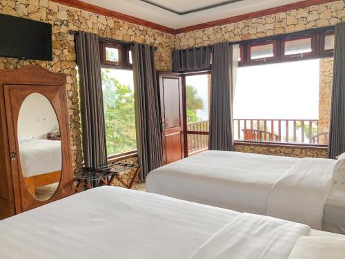 a bedroom with two beds and a large window at Edge Resort, Yogyakarta in Parangtritis