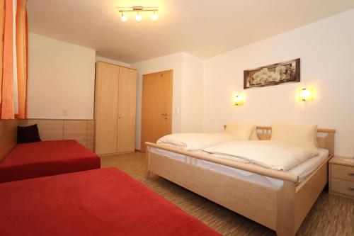 - une chambre avec 2 lits et un tapis rouge dans l'établissement Ferienhaus Brandacher, à Rohrberg