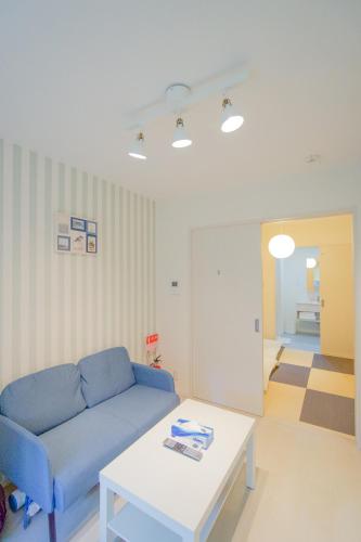 a living room with a blue couch and a table at HANASTAY花渓居 · 楓（KAEDE) in Osaka