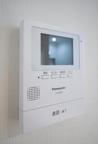 a white machine with a screen on a wall at HANASTAY花渓居 · 楓（KAEDE) in Osaka