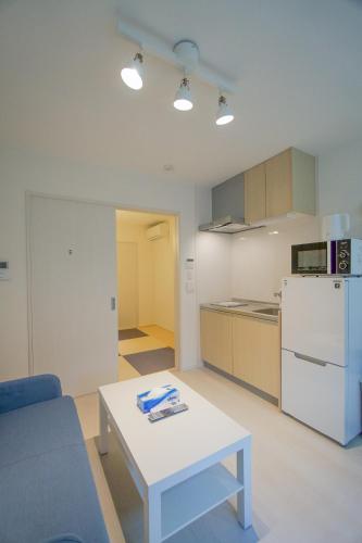 a living room with a table and a white refrigerator at HANASTAY花渓居 · 楓（KAEDE) in Osaka