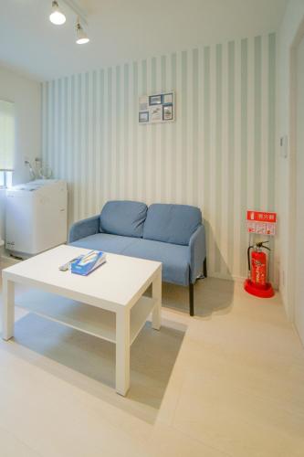 a living room with a blue couch and a table at HANASTAY花渓居 · 楓（KAEDE) in Osaka