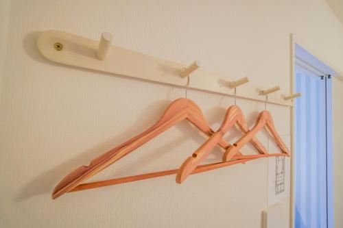 a pair of wooden hangers hanging on a wall at HANASTAY花渓居 · 楓（KAEDE) in Osaka