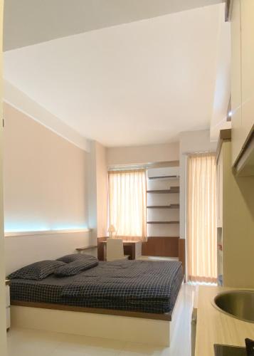 1 dormitorio con cama y lavamanos en Marda Room By Vivo Apartment en Yogyakarta