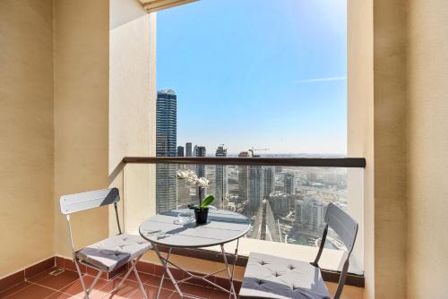 a balcony with a table and two chairs and a window at Beautiful Sea and Marina View - Premium 2BR in JBR in Dubai