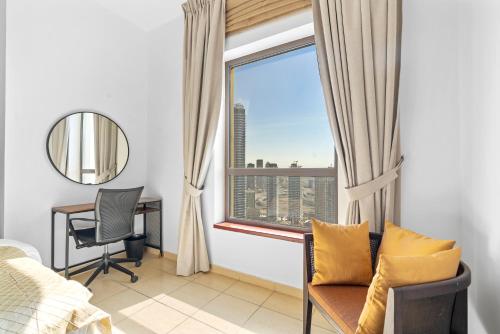 a bedroom with a bed and a desk and a window at Beautiful Sea and Marina View - Premium 2BR in JBR in Dubai