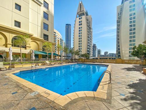 a swimming pool in a city with tall buildings at Beautiful Sea and Marina View - Premium 2BR in JBR in Dubai