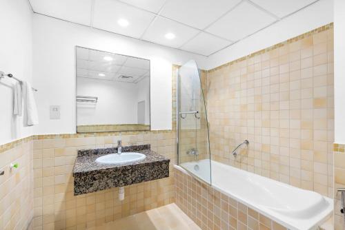a bathroom with a sink and a bath tub and a mirror at Beautiful Sea and Marina View - Premium 2BR in JBR in Dubai