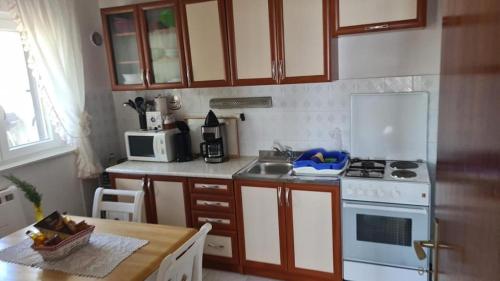 a kitchen with a white stove and a sink at Apartment Biondić in Starigrad