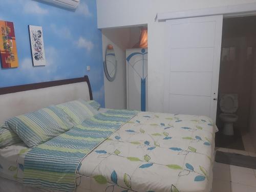 1 dormitorio con cama y pared azul en Villa kota bunga puncak, en Cianjur