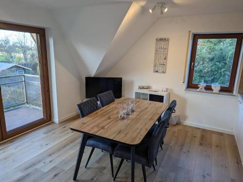 - une salle à manger avec une table et des chaises en bois dans l'établissement Dünengras, à Horumersiel