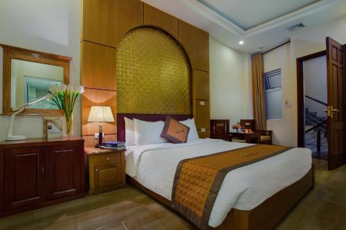 ハノイにあるVong Xua Boutique Hotelの大きなベッドとデスクが備わるホテルルームです。