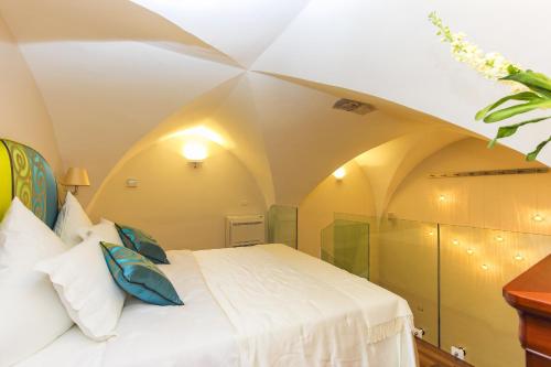 a bedroom with a white bed and a ceiling at DieciSedici in Amalfi