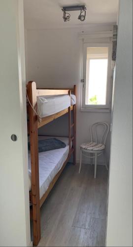 Cette petite chambre comprend 2 lits superposés et une chaise. dans l'établissement Cap Gruissan Vacances (11), à Gruissan