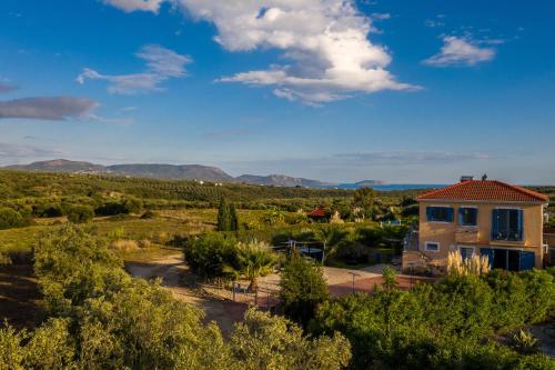 a house in the middle of a field with trees at Villa Finiki Messinia upstairs in Foiníki