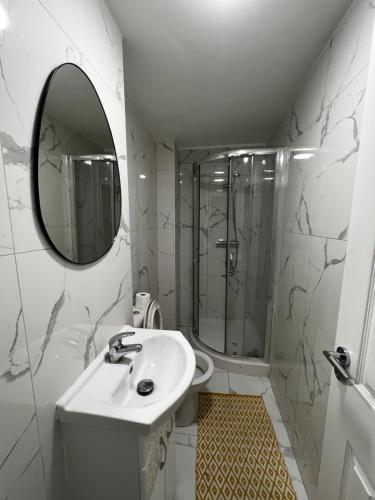 a bathroom with a shower and a sink and a mirror at Cozy flat London in London