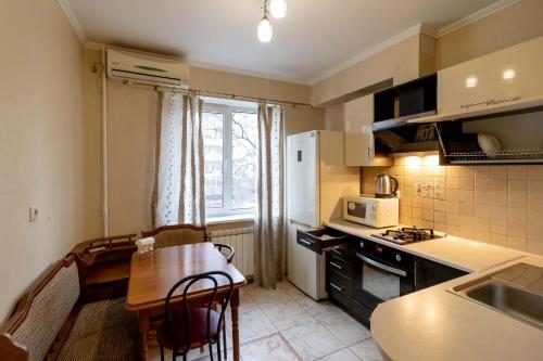 una pequeña cocina con mesa y una pequeña cocina con fregadero en Kvartirkoff na Geroev Dnepra 36 b en Kiev