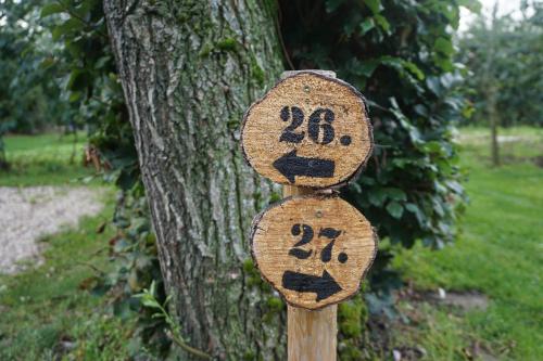 a wooden sign with the number on it next to a tree at Camping de Vliert in Bunnik