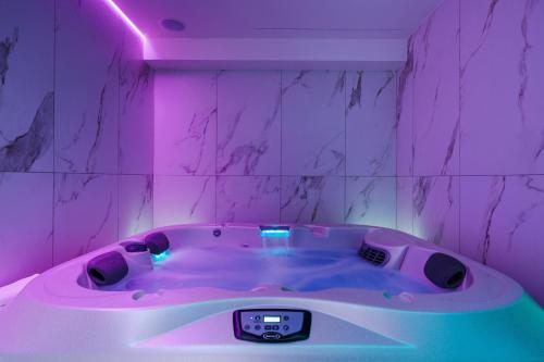 a purple room with a hot tub with a pink lighting at Life Hotel Seaview & Spa in Porto Recanati