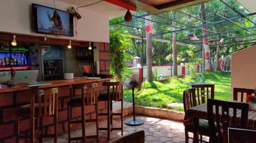 a bar in a restaurant with a view of a garden at Mary Joey in Baga