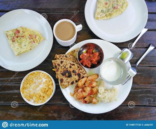 une table en bois avec des assiettes de nourriture dans l'établissement Hill Home Stay, Mankhim Road, Aritar, Sikkim, à Aritar