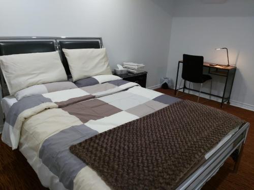 a large bed in a room with a chair at Guest House Room No 02 in Mississauga
