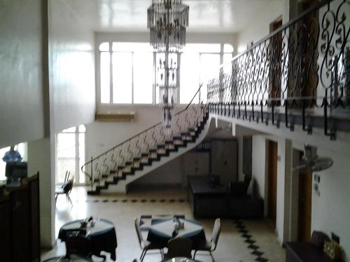 a staircase in a building with tables and chairs at Sophia Hotel in Dar es Salaam