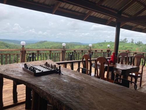a chess board on a wooden table on a deck at Natural House Farm Stay in Môndól Kiri