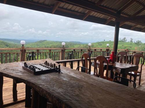 un tablero de ajedrez sobre una mesa de madera en una cubierta en Natural House Farm Stay, en Môndól Kiri