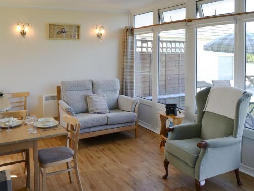 a living room with a couch and a table and chairs at Silver Bream in Brundall