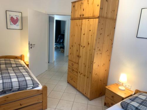 - une chambre avec 2 lits et une armoire en bois dans l'établissement Jordsand, à Horumersiel