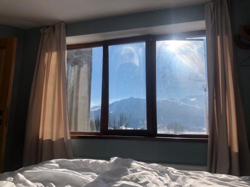 a bedroom with a window with a view of a mountain at Bakuriani Fun, nice view and design, cosy and spacious in Bakuriani