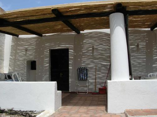 a white house with a wooden roof and a patio at Ca Balena piccola e grande in Stromboli