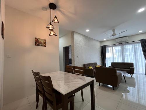 a dining room and living room with a table and chairs at Airbnb Homestay P Residence in Kuching