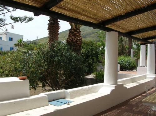 a porch with a palm tree in the background at Ca Balena piccola e grande in Stromboli