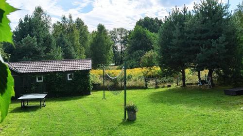 a garden with a net in the middle of a yard at Lawendowa Malanówka - domek nad jeziorem in Radęcin
