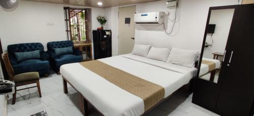 1 dormitorio con 1 cama y 2 sillas azules en Mary Joey en Baga