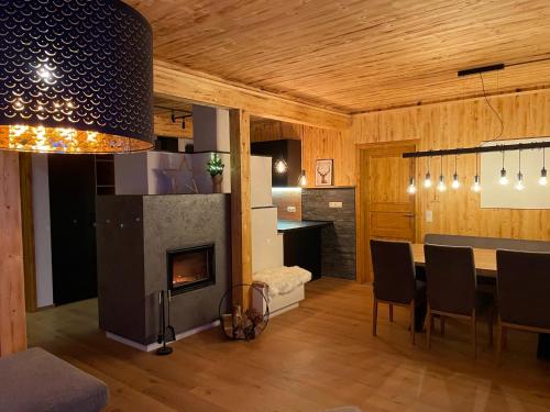 a dining room with a fireplace and a dining table at Hillside Chalet Kreischberg in Sankt Lorenzen ob Murau