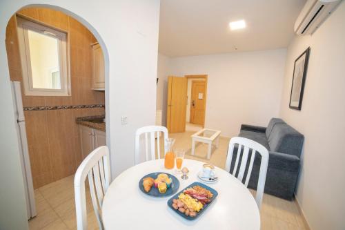 a dining room with a white table with food on it at Hotel Apartamentos Pyr Fuengirola in Fuengirola