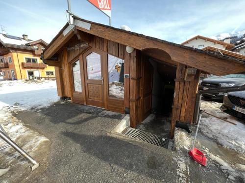 un piccolo edificio in legno con una porta nella neve di Hotel Galli's - Centro a Livigno