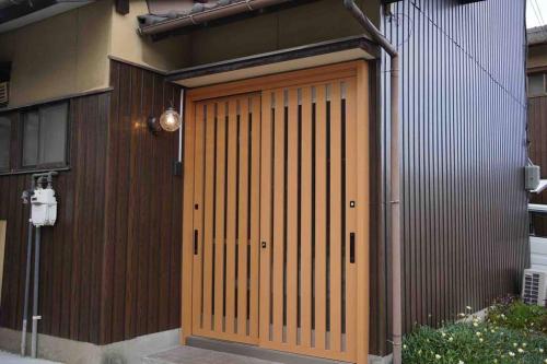 a wooden garage door on a building with at 吉田邸　古民家の落ち着いたお家 in Ichimonji