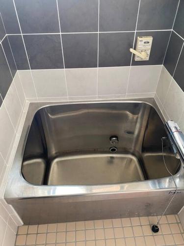 a stainless steel sink in a corner of a bathroom at 吉田邸　古民家の落ち着いたお家 in Ichimonji