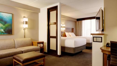 a hotel room with two beds and a couch at Sonesta Select Austin North Central in Austin