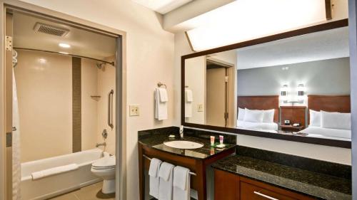 a bathroom with a toilet sink and a large mirror at Sonesta Select Austin North Central in Austin